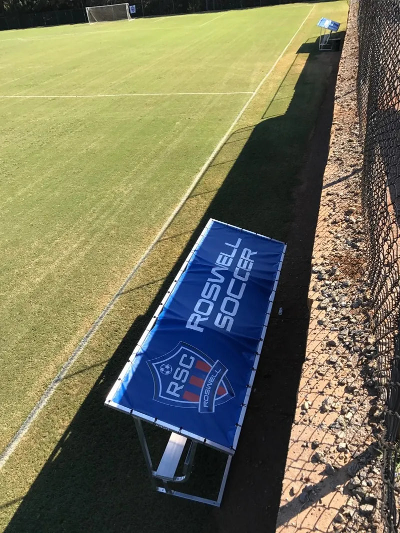 Overhead view of a blue Roswell Soccer tarp with white lettering and a red, white, and blue RSG crest.