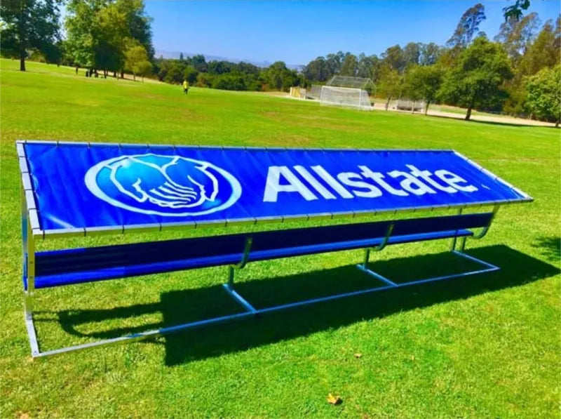 Rear angled view of an aluminum covered bench with a royal blue tarp and white Allstate logo and lettering.
