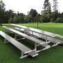 Hero image: three-row aluminum stadium bleachers at an outdoor athletic field