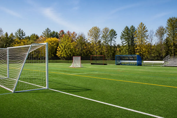 September multi-sport school field with soccer goal, lacrosse goal, team shelter, and bleachers