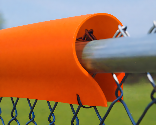 Orange fence top safety guard installed on a chain link fence for baseball field and sports facility protection