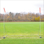 Jaypro portable high school football practice goal with H-frame, wheels, and red wind streamers on a grass field.