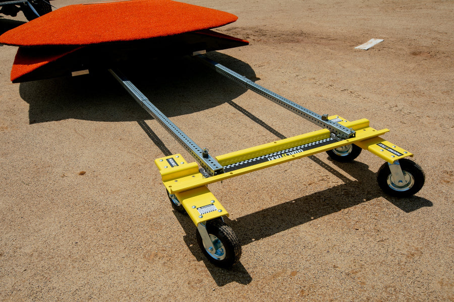 Mound Taxi positioned under a portable pitching mound on a baseball infield