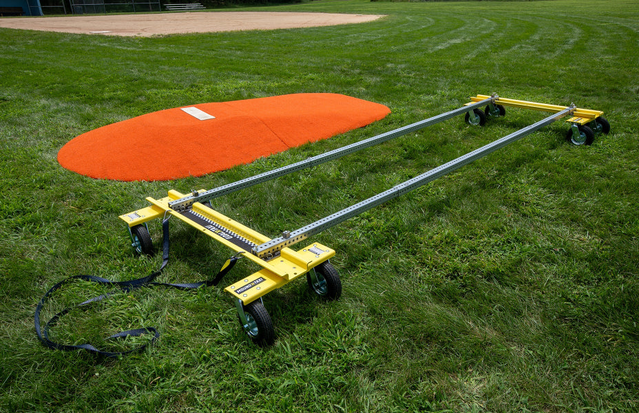Mound Taxi assembled beside orange portable pitching mound on grass field