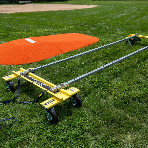 Mound Taxi assembled beside orange portable pitching mound on grass field