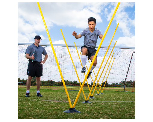 Athlete performing agility ladder style drill through Pro Agility Pole Set with coach supervising on soccer field