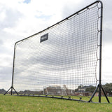 Large black sports net on a grassy field with a cloudy sky.