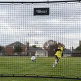 Person playing soccer on a field with a goal net in the foreground