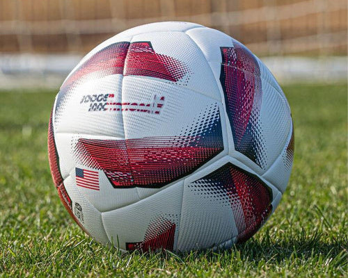 Spark Soccer Ball 2026 USA edition size 5 in red white and blue on grass field near soccer goal net