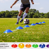 Soccer player dribbling ball through blue disc cones during agility training on grass field