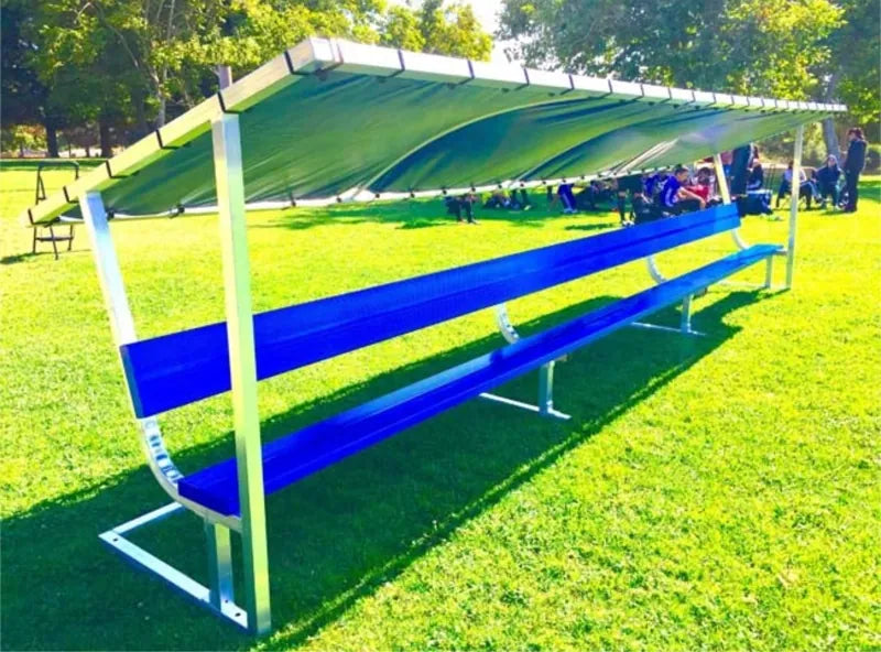 Front left view of a 21ft covered bench with blue seat and backrest, silver frame, and greenish tarp underside.