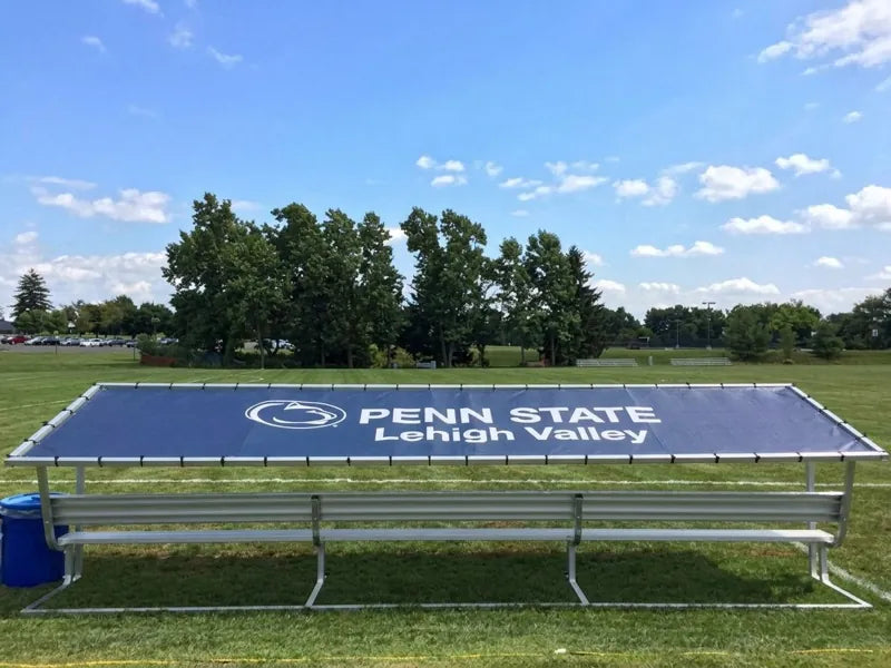Rear view of a Penn State Lehigh Valley covered bench with a navy blue tarp, white logo, and lettering.